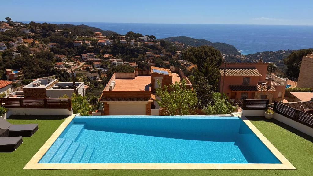 a blue swimming pool on top of a house at Villa Irene - Vistas al mar in Lloret de Mar