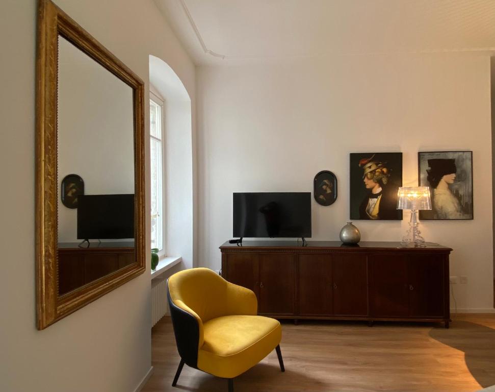 a living room with a yellow chair and a mirror at Rebassotto in Rovereto