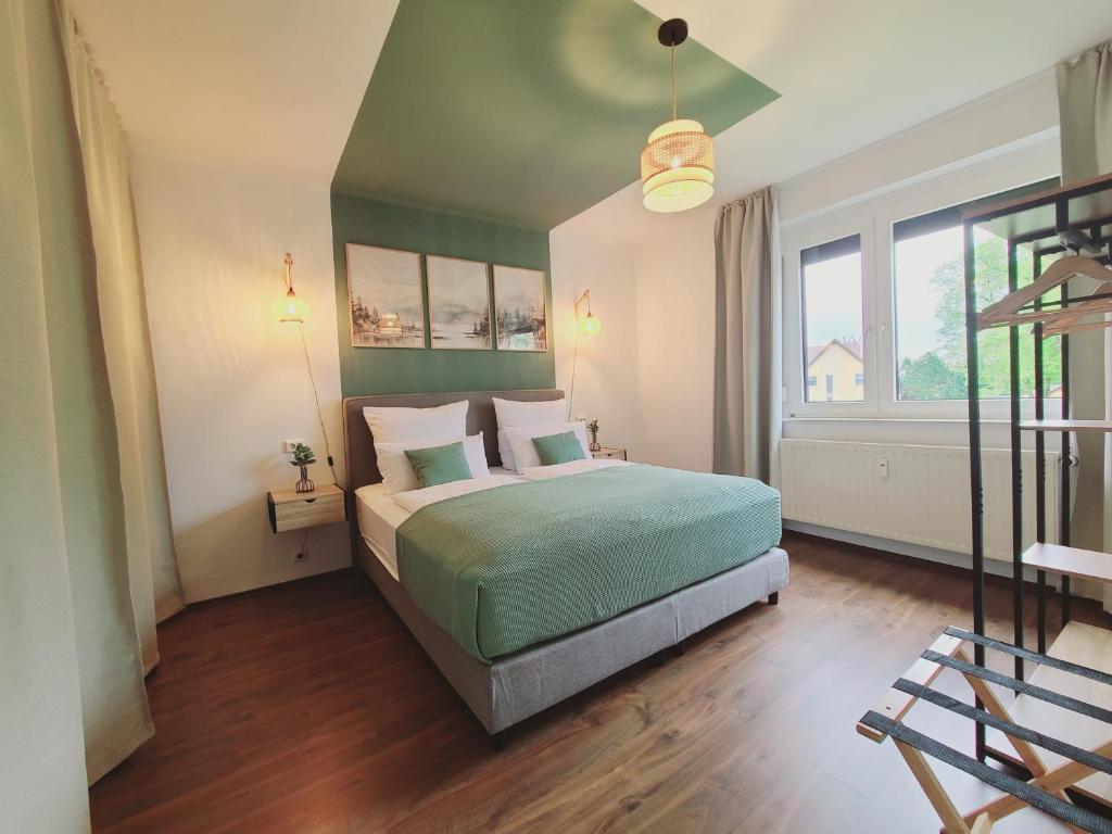 a bedroom with a green bed and a large window at Neu! Spreelounge Apartments! Ihre Auszeit im Herzen des Spreewalds in Lübben