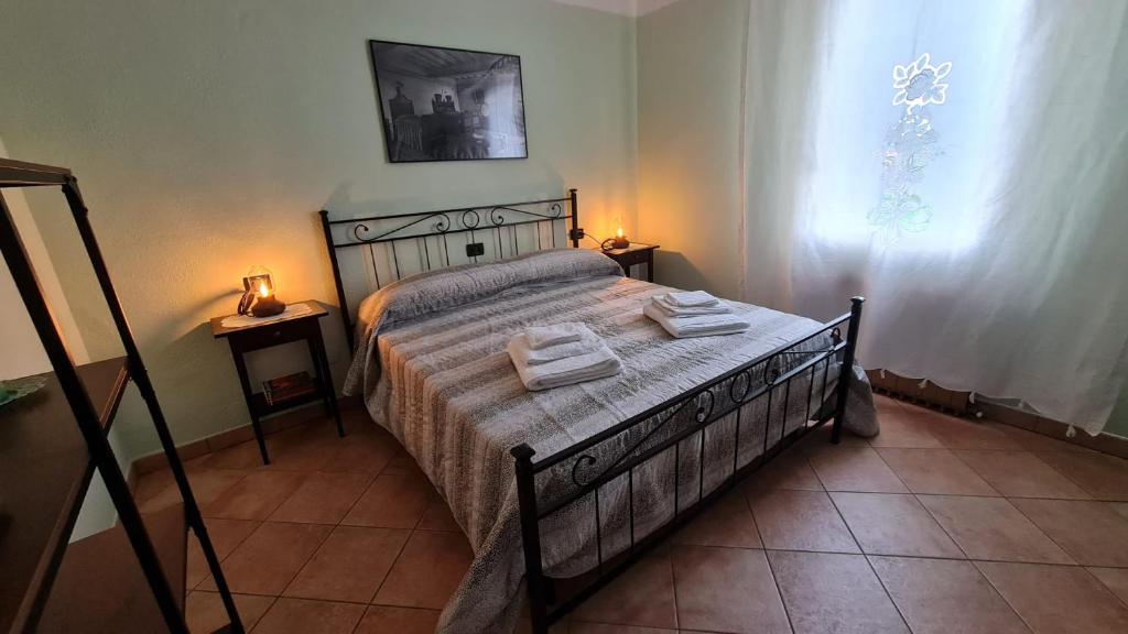 una camera da letto con un letto con due asciugamani sopra di Foresteria due Galli a San Martino del Lago