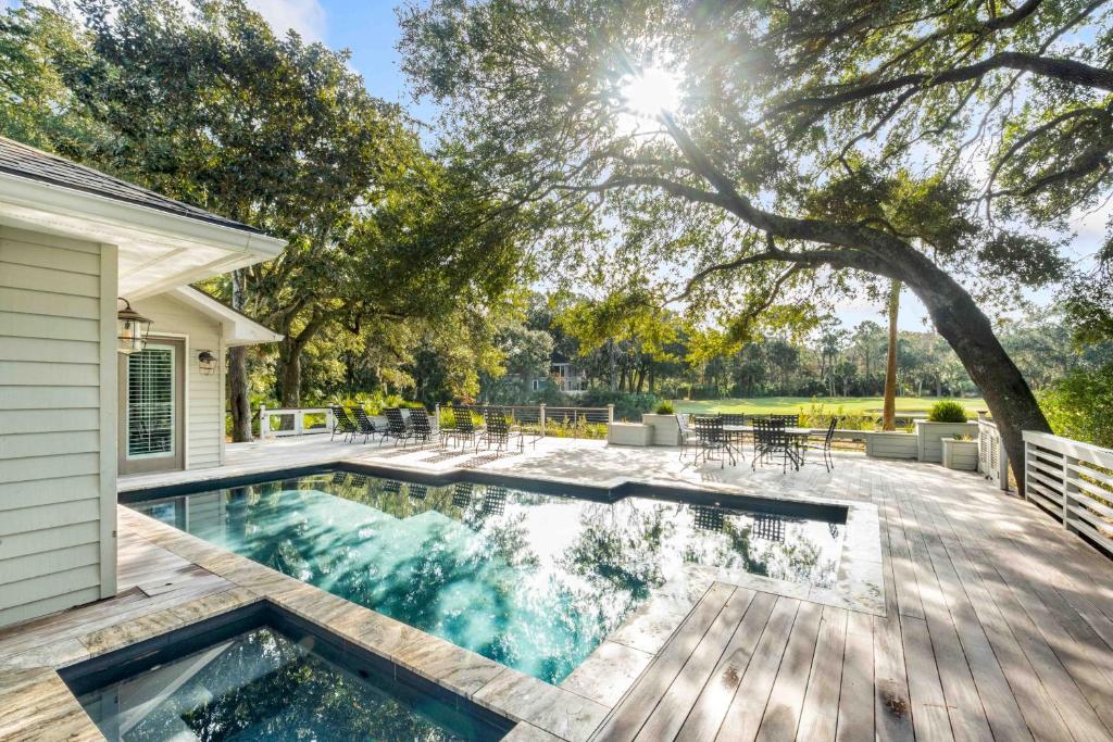 a swimming pool on a wooden deck with a tree at 151 Augusta National Court by Akers Ellis Rentals in Kiawah Island