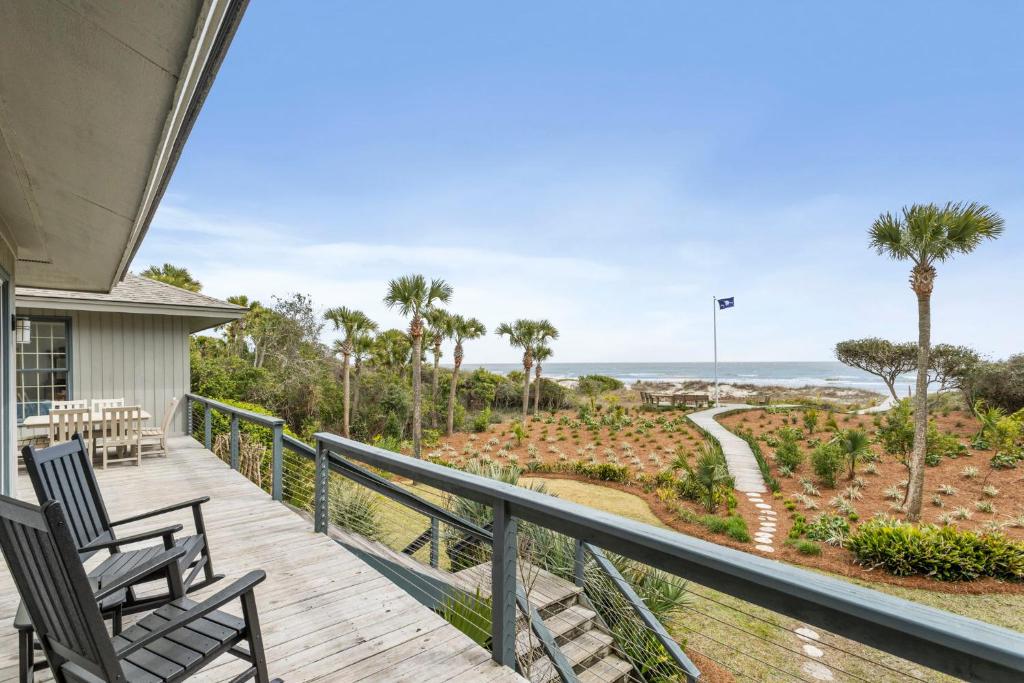 a deck with two chairs and a view of the ocean at 19 Eugenia Avenue by Akers Ellis Rentals in Kiawah Island