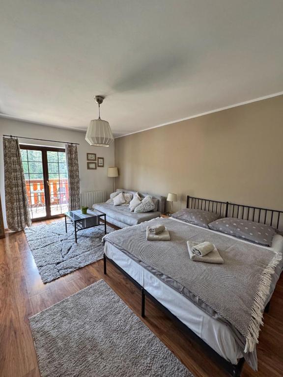 a bedroom with two beds and a large window at Apartment Barbora 2 in Ružomberok