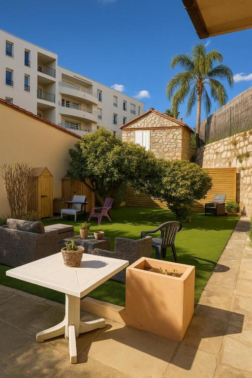 a patio with a table and chairs in a yard at La maison de Giulia Menton in Menton