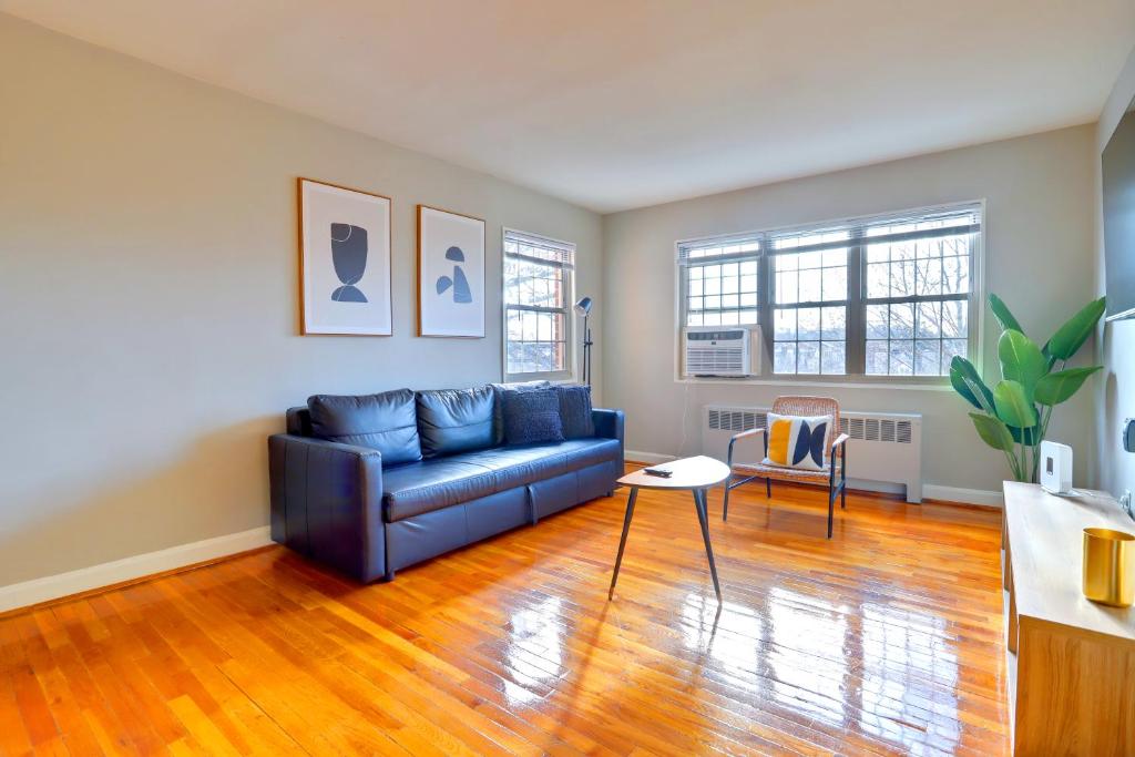 a living room with a blue couch and a table at Business Ready Apartment in Alexandria Modern & Central Location in Alexandria