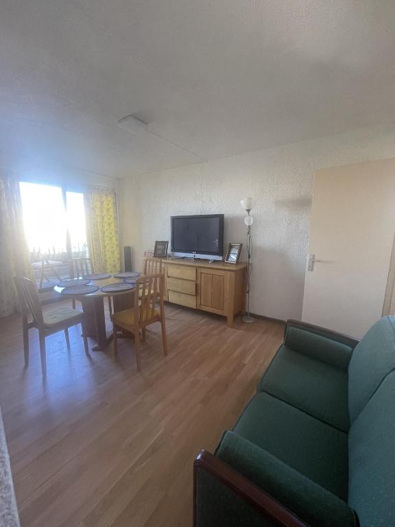 un salon avec un canapé, une table et une télévision dans l'établissement Appartement T3 2ème étage, à Seignosse