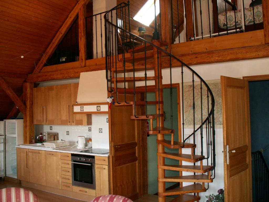 eine hölzerne Wendeltreppe in einer Küche mit Holzschränken in der Unterkunft La grange in Menthon-Saint-Bernard