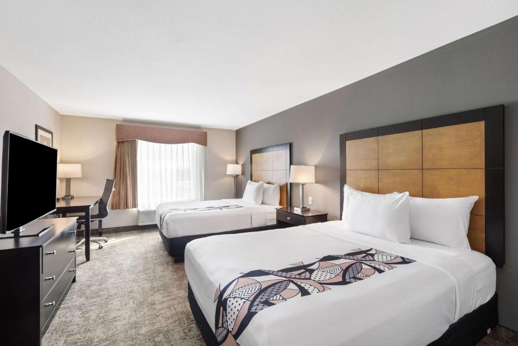 a hotel room with two beds and a flat screen tv at Best Western Inn & Suites - Midway Airport in Burbank
