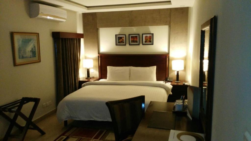 a hotel room with a bed and a table at Hotel One Super, Islamabad in Islamabad