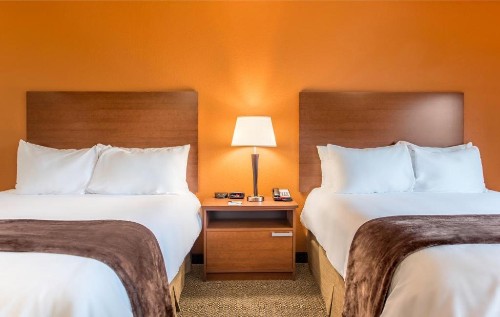 a hotel room with two beds and a table with a lamp at My Place Hotel Rapid City in Rapid City