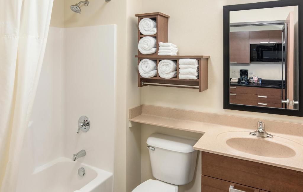 a bathroom with a toilet and a sink and a mirror at My Place Hotel Rapid City in Rapid City