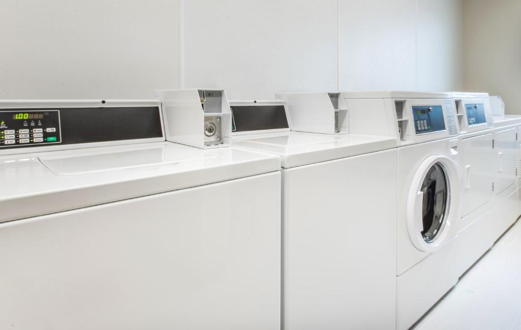 a white washing machine in a white laundry room at My Place Hotel Rapid City in Rapid City