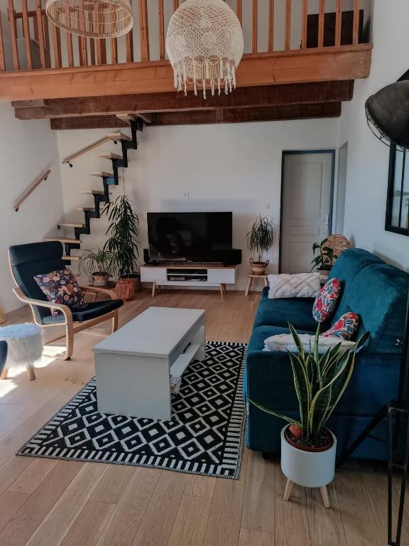 - un salon avec un canapé bleu et un escalier dans l'établissement Apparement Duplex avec jacuzzi, à Saint-Georges-dʼOrques