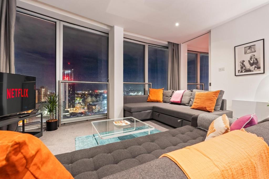 een woonkamer met een bank en een tv bij 25 World Famous Rotunda 18th floor skyline views in Birmingham