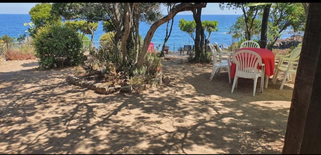 un patio con sedie e un tavolo di fronte all'oceano di Villa pied dans l eau a Cala dʼOro