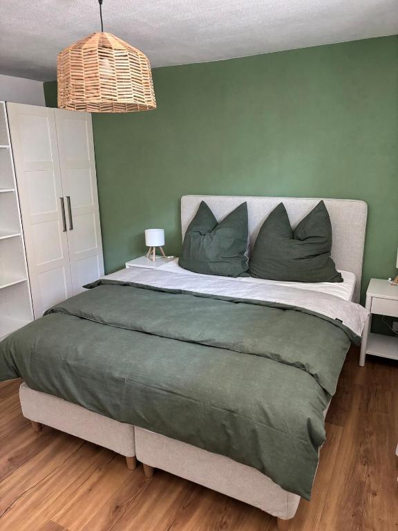 a bedroom with a large bed with green walls at Bergzauber in Pfronten