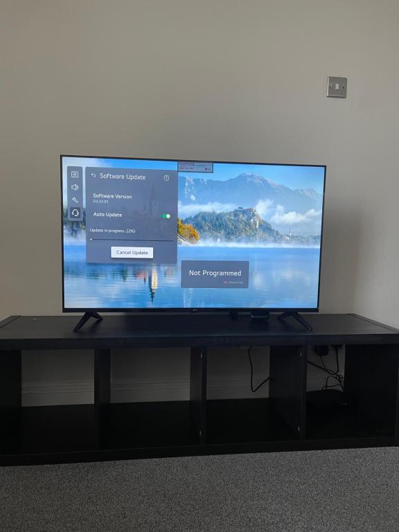 a flat screen tv sitting on a black table at London Holiday Home - 8mins walk from Station Zone 2 in Moffat