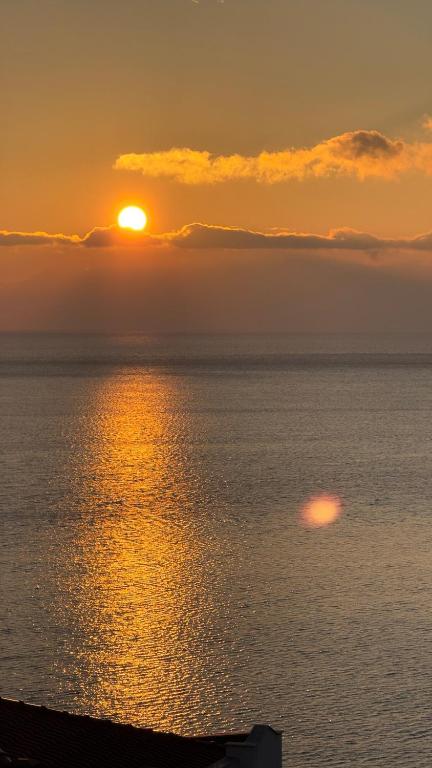a sunset over the ocean with the sun in the sky at Hermes View in Kavála