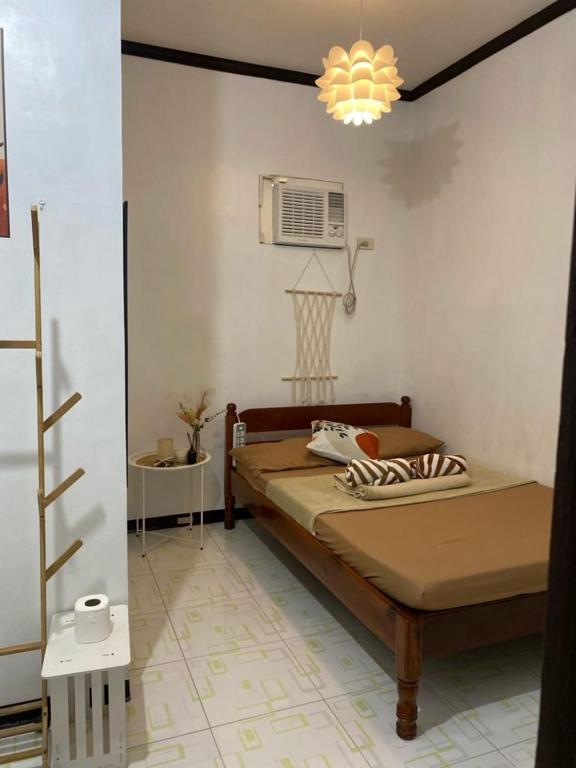 een kleine slaapkamer met een bed en een ventilator bij Happy Feet Siargao Homestay -General Luna in General Luna