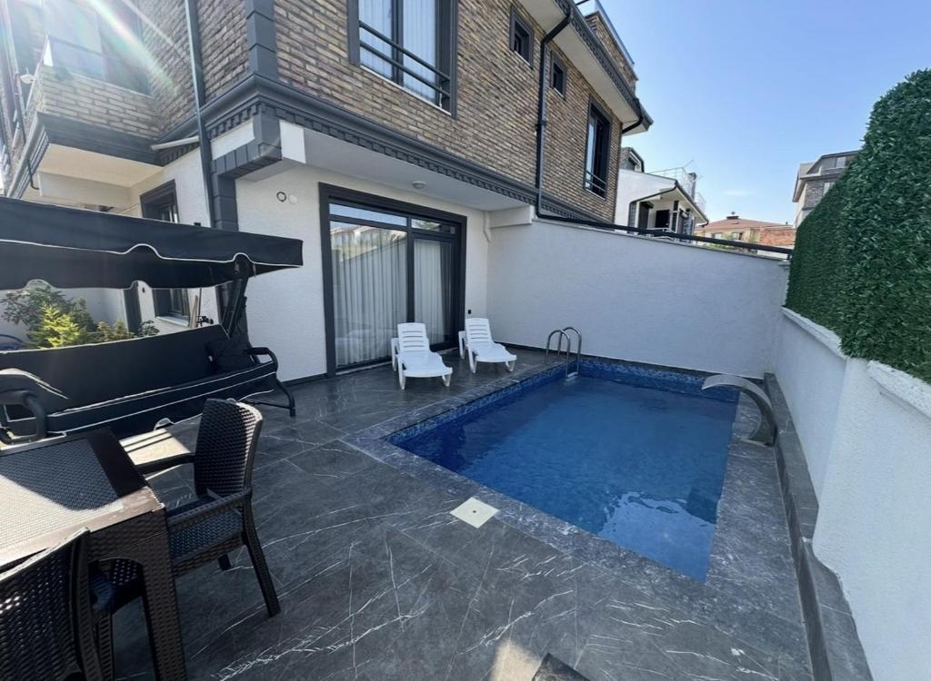 a swimming pool on the side of a house at Villa Ayla in Yukarı Kocaali