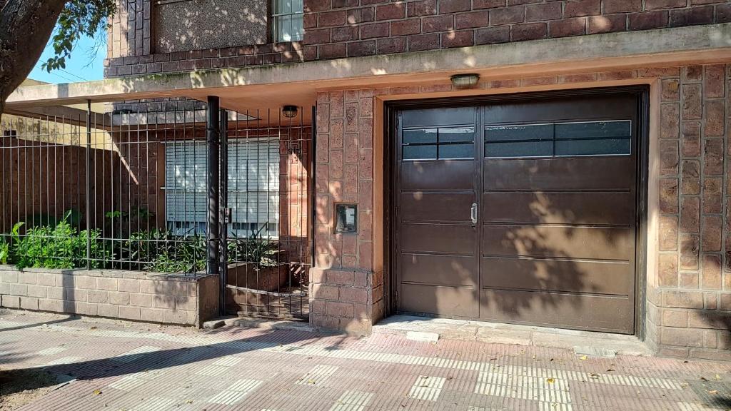 eine braune Garagentür in einem Backsteingebäude in der Unterkunft Amplia casa cerca del centro de la ciudad in Cordoba