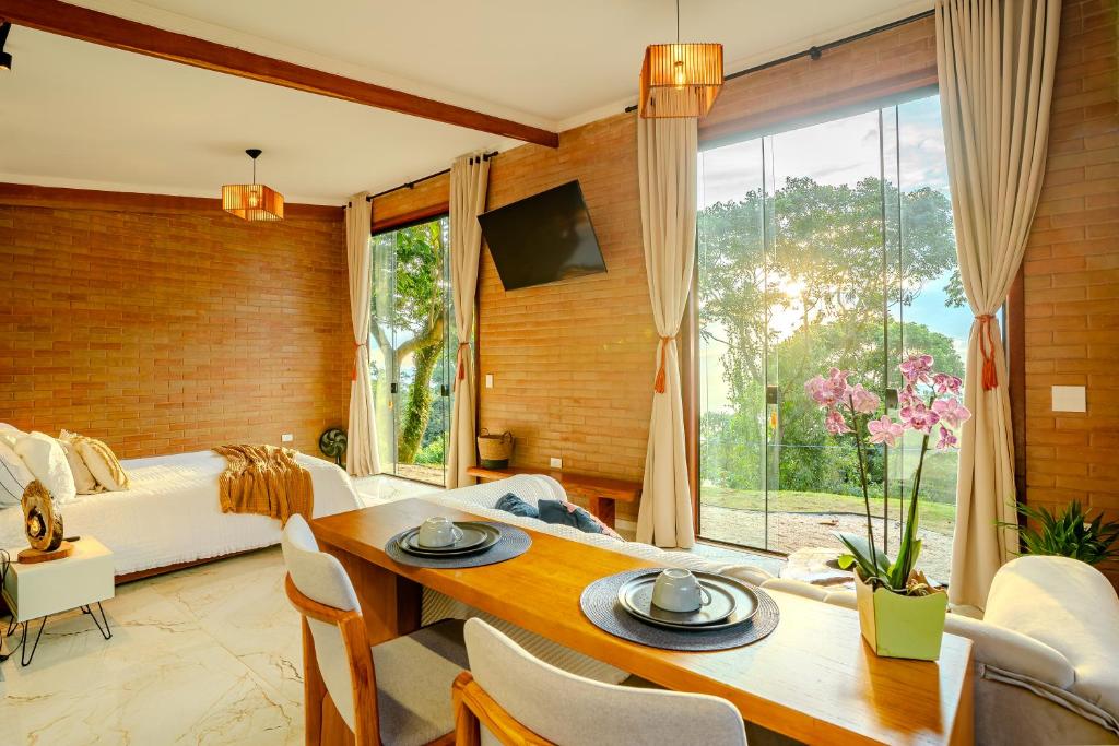 a bedroom with a bed and a dining room with a table at Cabana nas montanhas em Campos do Jordão in Campos do Jordão