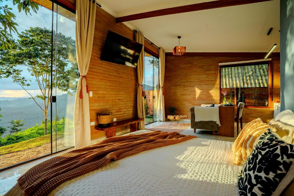 a bedroom with a bed and a large window at Cabana nas montanhas em Campos do Jordão in Campos do Jordão