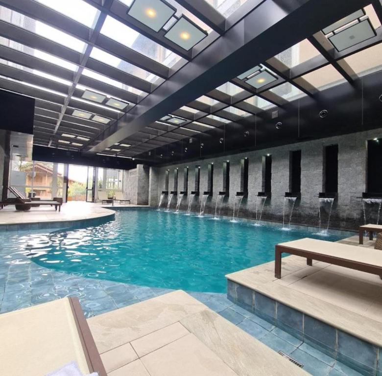 Una gran piscina con agua azul en un edificio. en Ap 311 ou 312B Exclusive Gramado, en Gramado
