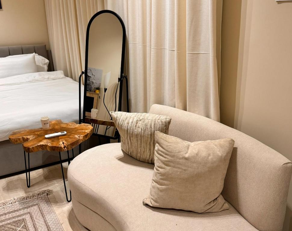 Habitación con sofá, espejo y cama. en استديو انيق بحي السليمانيه, en Riad