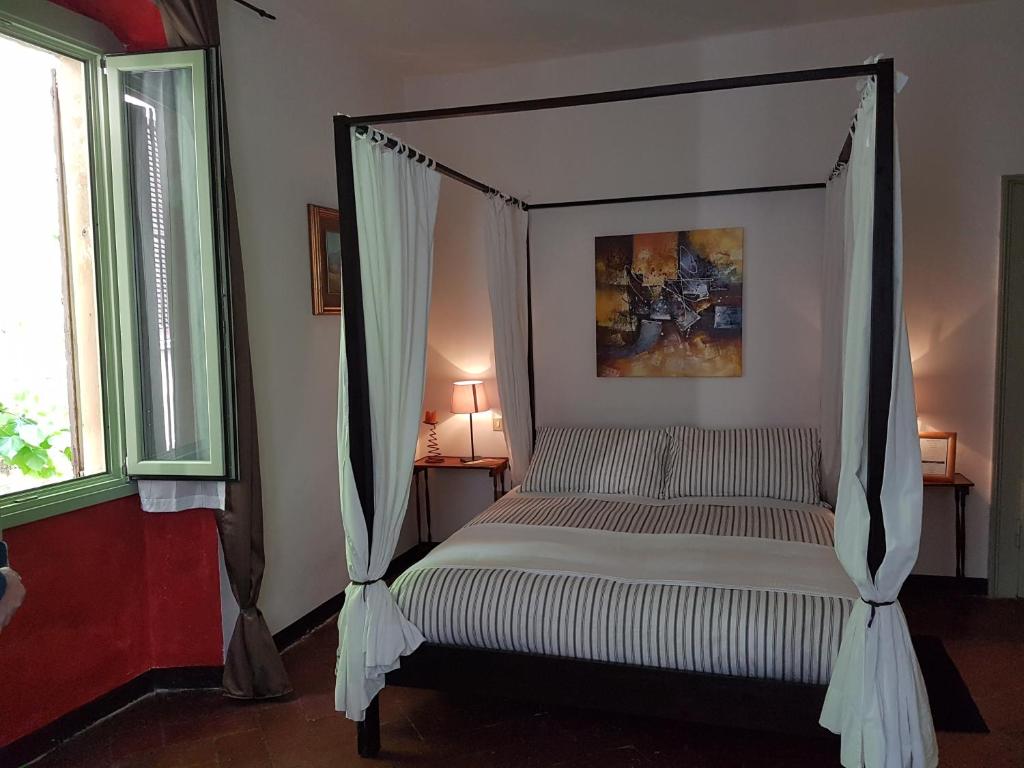 un letto a baldacchino in una camera con finestre di Mich&Letti a Brescia