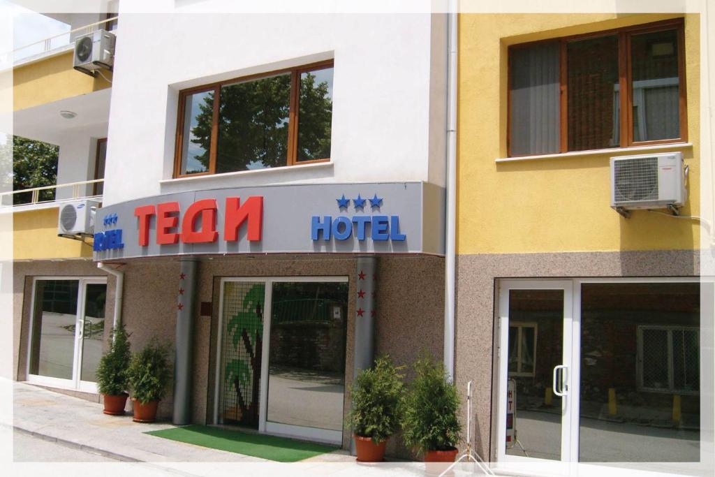 een gebouw met een treinhotelbord ervoor bij hotel TEDI in Asenovgrad