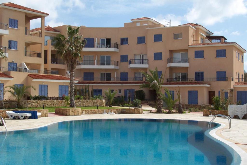 a large apartment building with a large swimming pool at King's Palace Apartment in Paphos