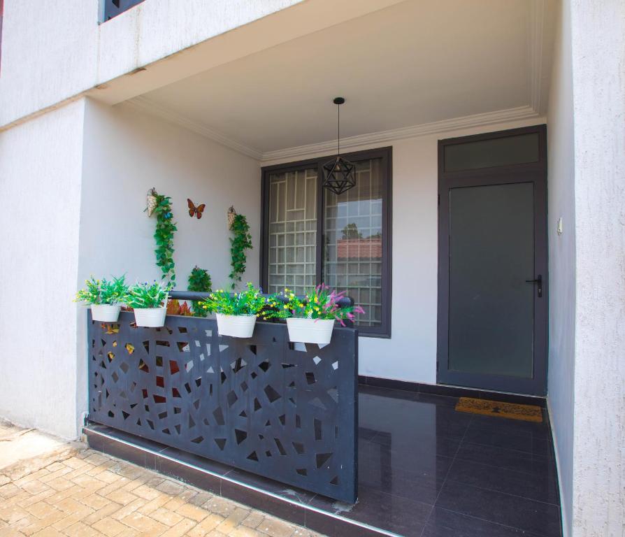 a front porch with potted plants on a fence at Luxury 2 bedroom Apartment near The Under bridge in Trofwi