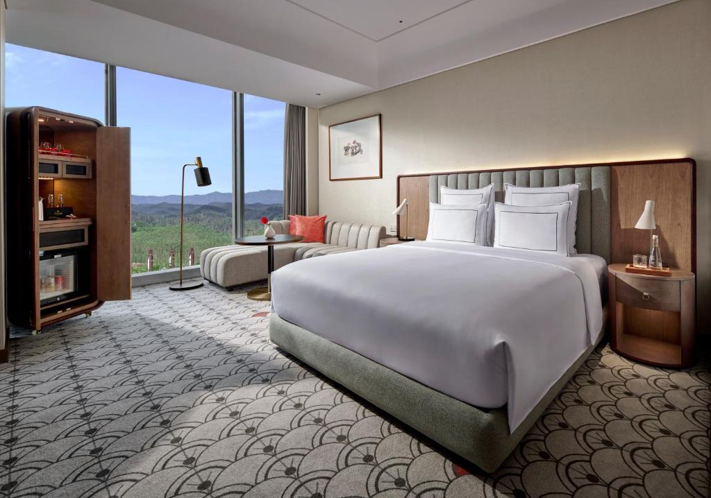 Postel nebo postele na pokoji v ubytování Swissôtel Nusantara