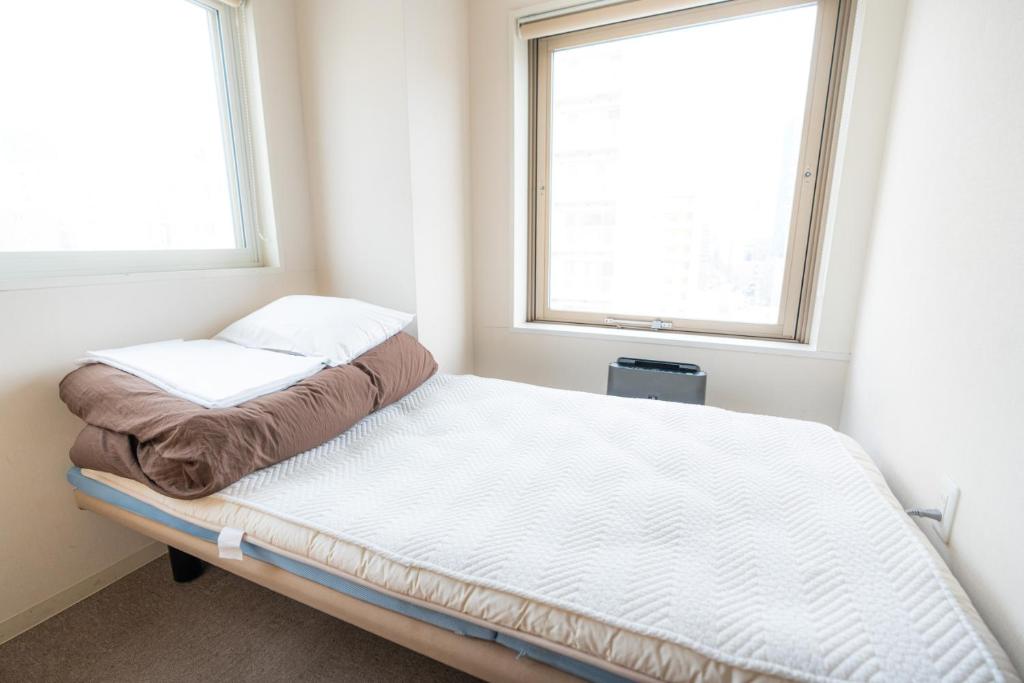 Postel nebo postele na pokoji v ubytování Grand Hostel LDK Sapporo