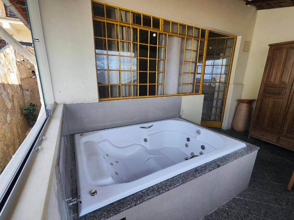 a large bath tub in a bathroom with a window at Hotel Montanhas de Minas in Diamantina