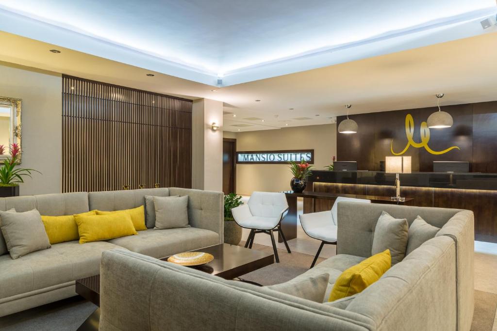 a living room with couches and a bar at Mansio Suites The Headrow in Leeds