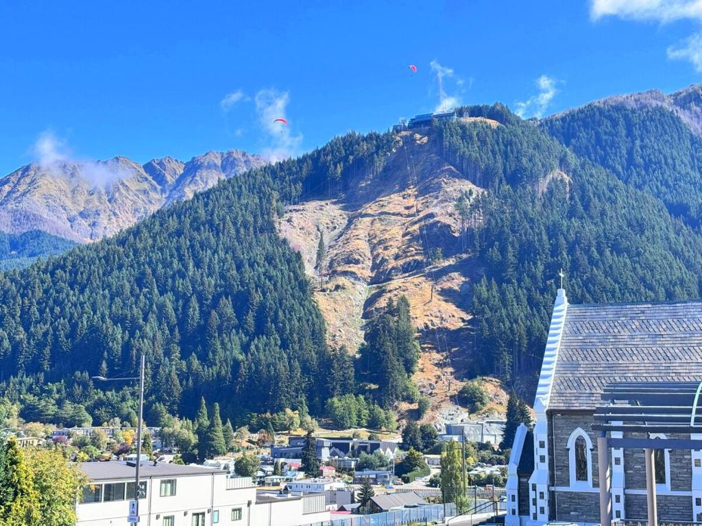 a view of a mountain with a town and a city at Central City Queenstown Retreat - 3 Bedroom Apartment in Queenstown