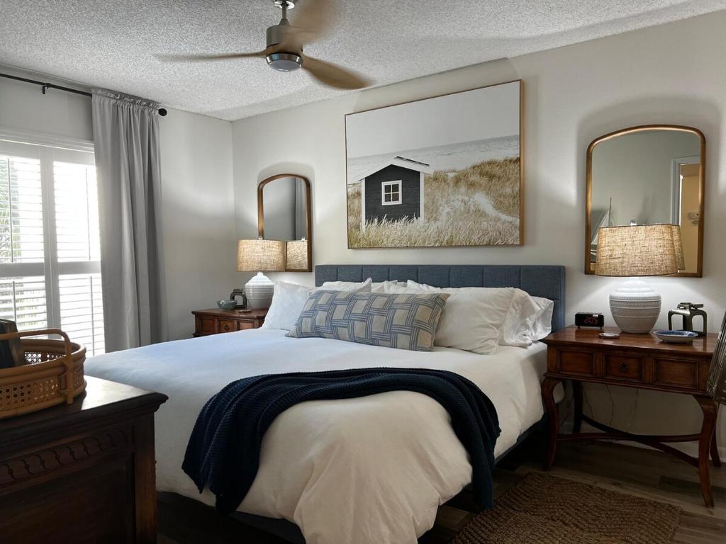 a bedroom with a large bed and two mirrors at Boutique Beachside condo with easy access to beach in Saint Augustine