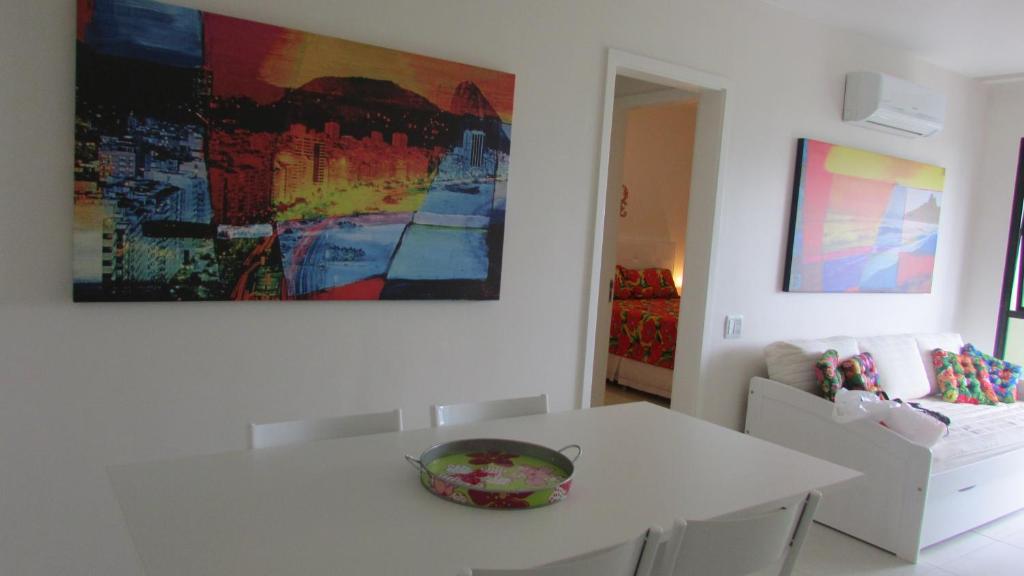 a dining room with a white table and a painting on the wall at 439 Barrabela in Rio de Janeiro