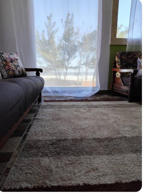 ein Wohnzimmer mit Couch und großem Fenster in der Unterkunft Pé na areia in Arraial do Cabo