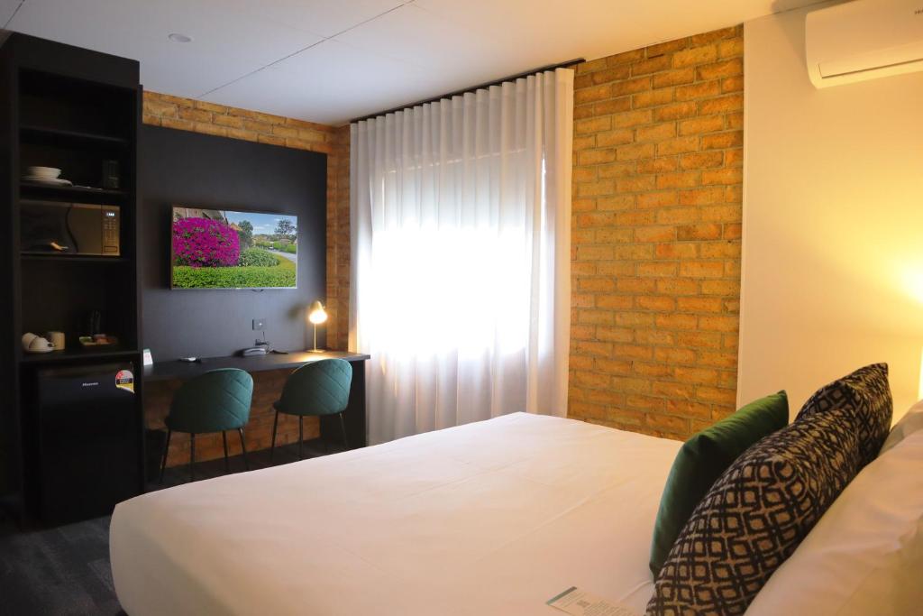 a hotel room with a bed and a desk at Quality Hotel Robertson Gardens in Brisbane