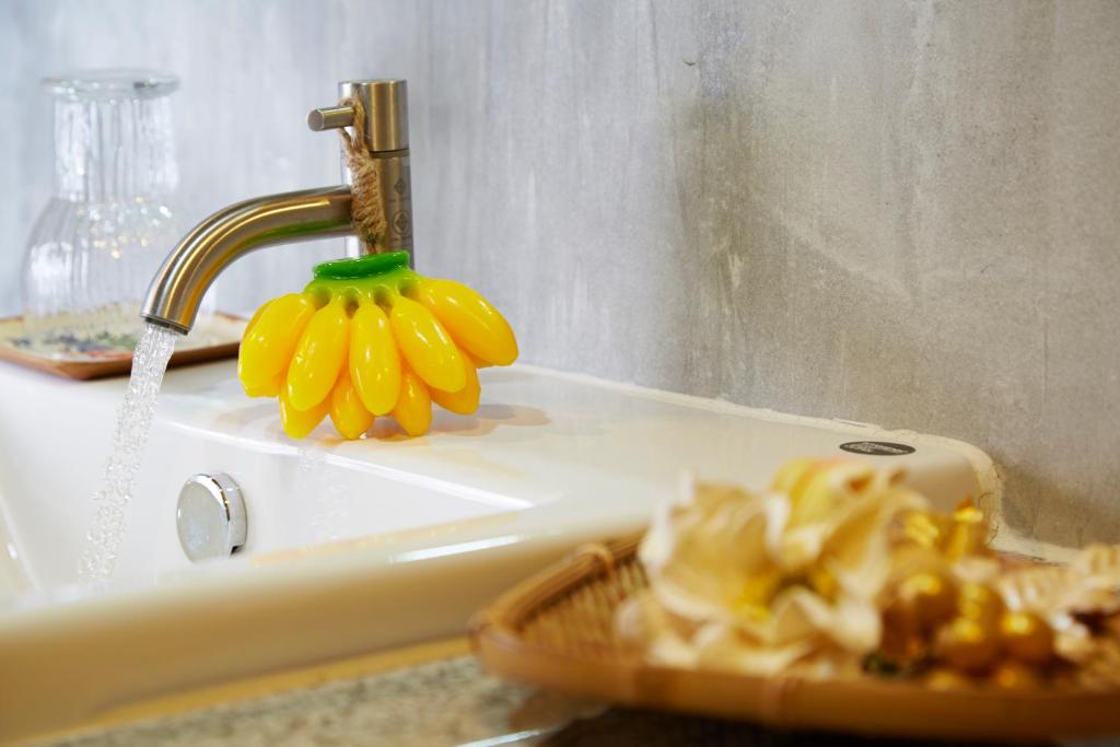 a bathroom sink with a faucet with a flower on it at Uncle Loy's Boutique House in Bangkok