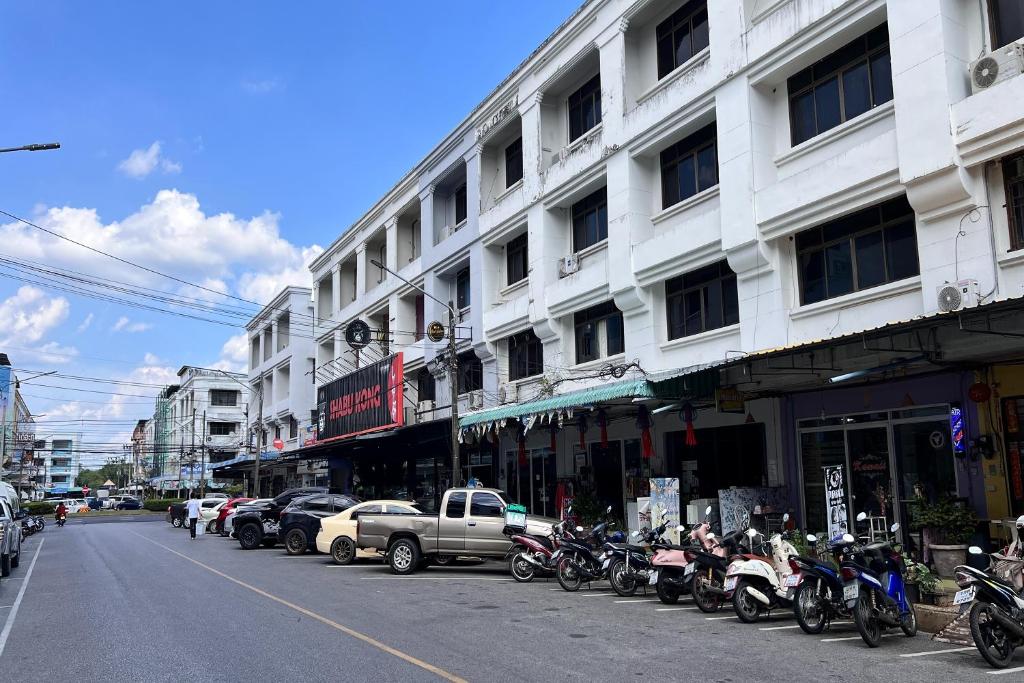 a white building with motorcycles parked on the side of a street at Bed Station Hostel Krabi in Ban Khlong Chi Lat