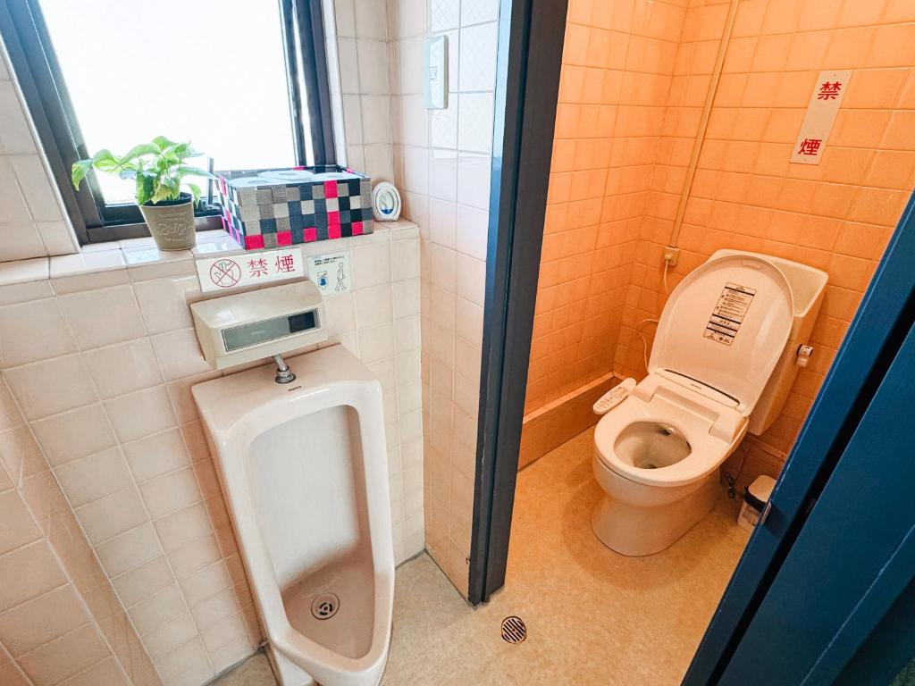 a bathroom with a urinal and a toilet in it at Mori Hotel in Osaka