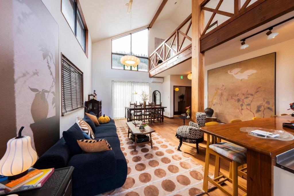 a living room with a blue couch and a table at 小景 绿a棟 擁有私人露天溫泉 與由布岳四季對望 免費接送 免費停車 in Yufuin