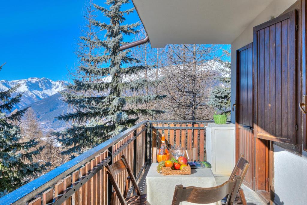 a table and chairs on a balcony with a christmas tree at Appartamento Il Rio - Happy Rentals in Sauze d'Oulx