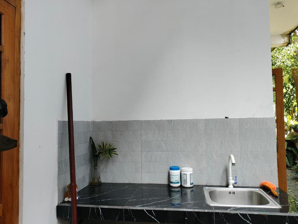 eine Küchentheke mit Spüle neben einer Wand in der Unterkunft Laveranda Apartment ground floor and laverenda apartment upstairs in Nikawatawana
