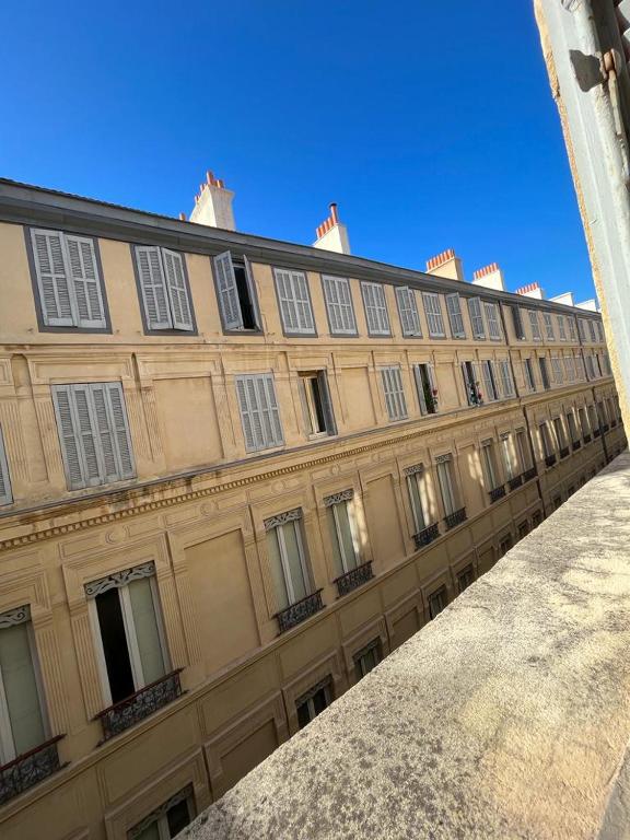 - un grand bâtiment avec des fenêtres sur le côté dans l'établissement Charmant T2 rénové, proche du Vieux Port, à Marseille