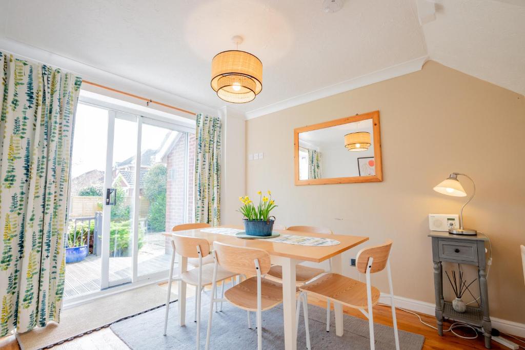 a dining room with a table and chairs and a window at Stylish 3-Bed, Garden & Secure Parking - M5 5 mins in Hindlip
